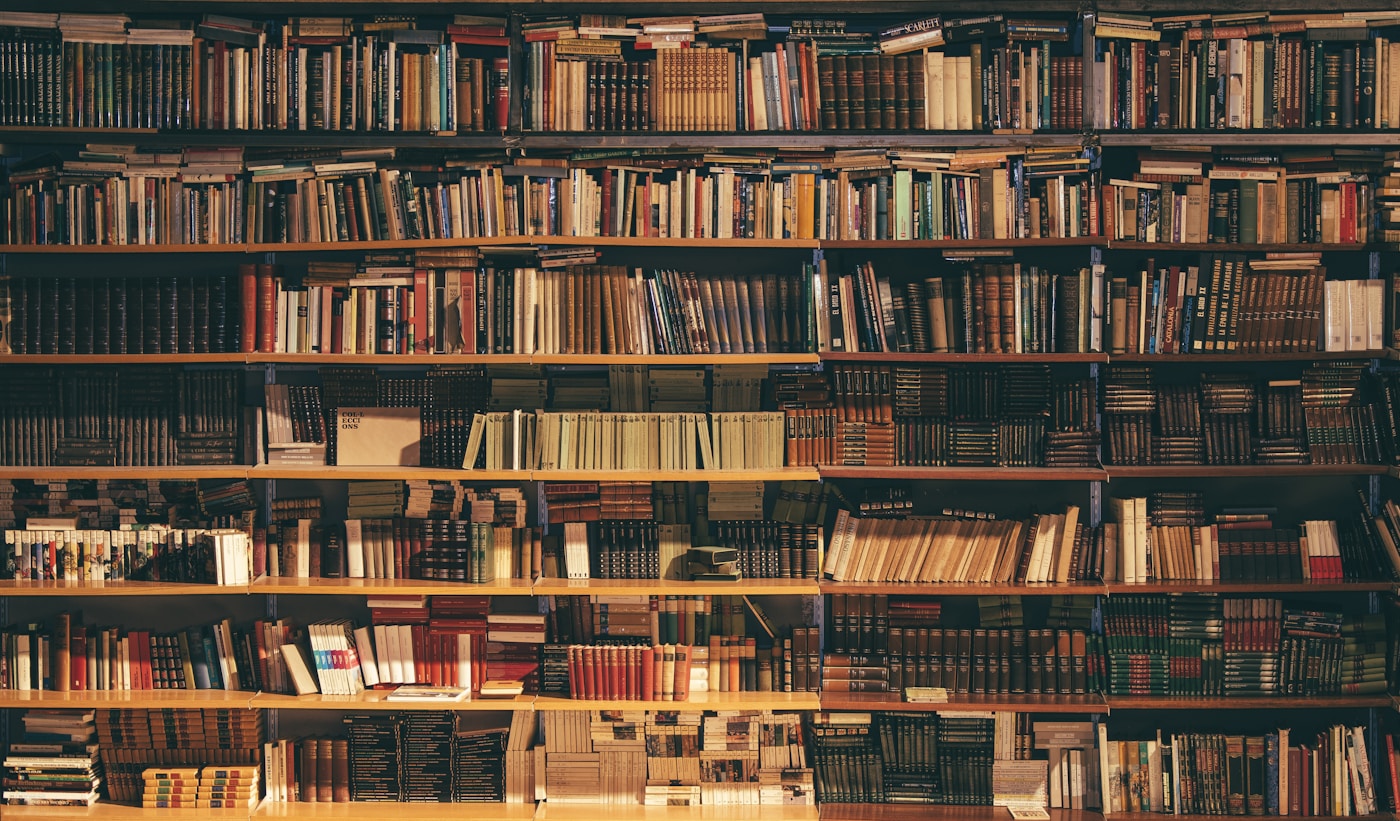 Stack of books on a dark desk — journaling and shadow work reflection
